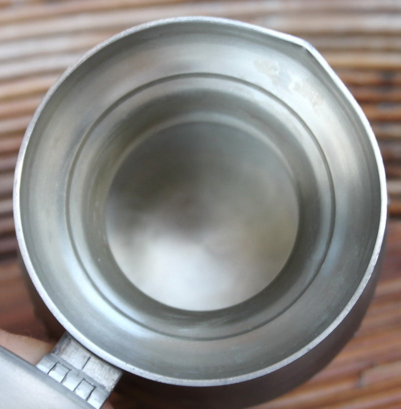 Vintage tin pitcher with bas-reliefs