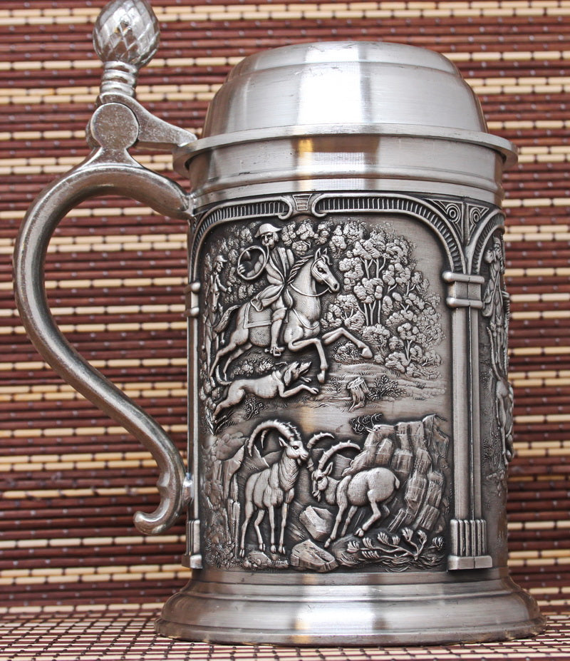 Vintage pewter mug with bas-reliefs. Ancient hunting