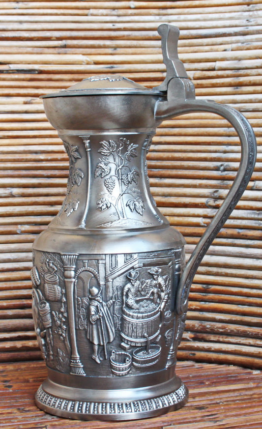 Vintage tin pitcher with bas-reliefs